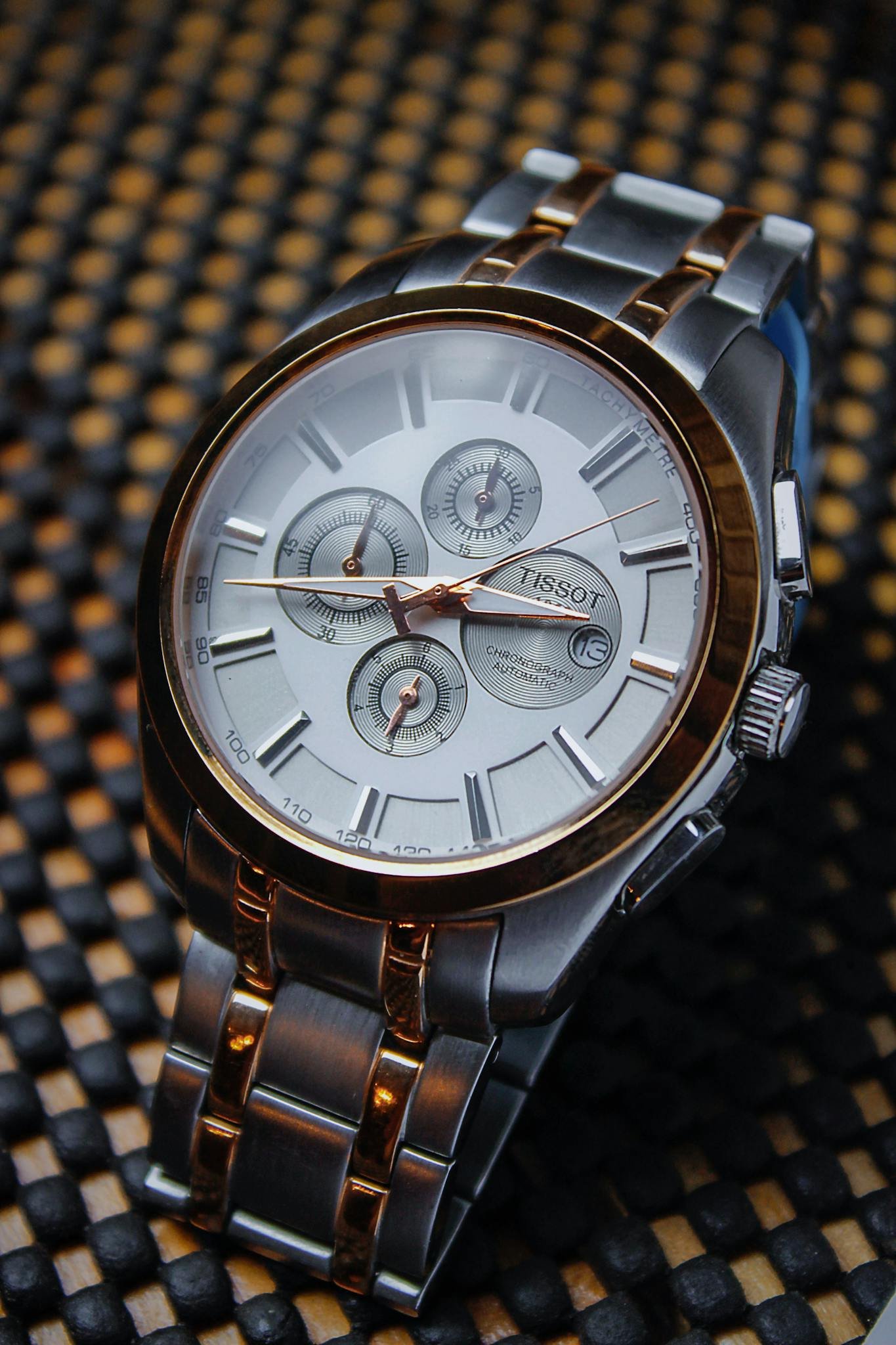 Detailed close-up of a luxurious Tissot wristwatch with metallic finishes.